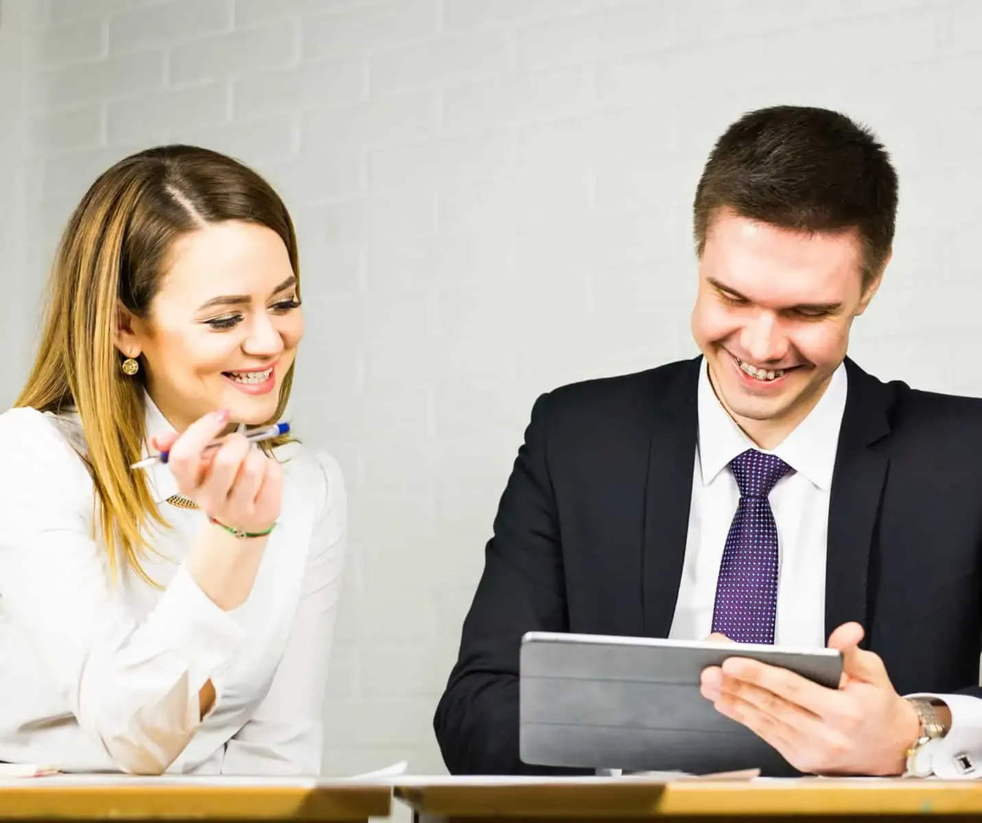 Prérequis ISO 9001 – Homme qui explique a une femme sur une tablette – Capcertification