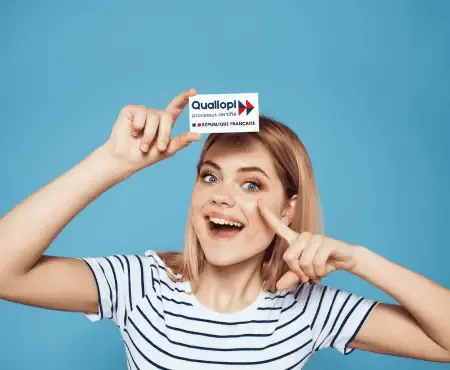 certification qualiopi décret du 31 mai 2023 capcert. Image représentant une jeune femme aux cheveux courts avec un air étonné tendant au-dessus de sa tête une petite carte sur lequel nous retrouvons le logo Qualiopi.